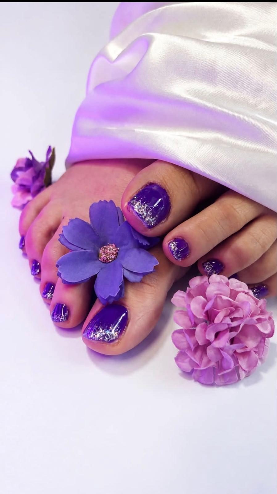 Kosmetische Fußpflege: violetter Lack mit Glitzer und Blumen