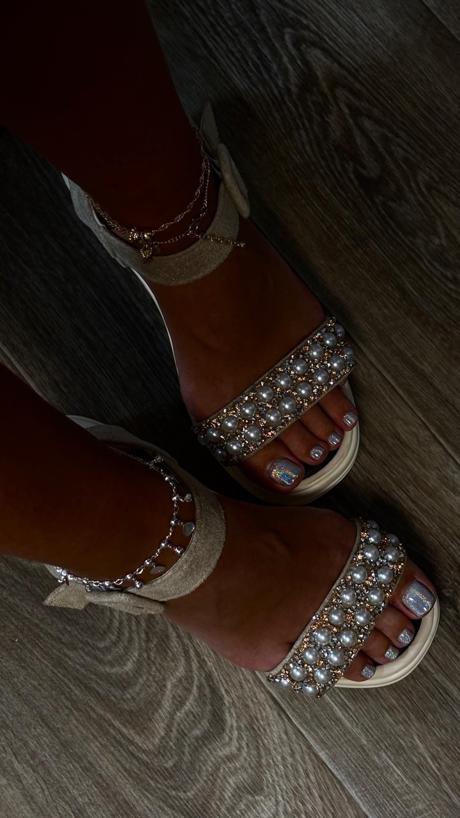 Kosmetische Fußpflege: perlmuttfarbener Glitzerlack in Perlensandalen